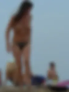Sexy babe with a nice body topless and in a thong on the beach