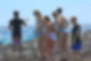 Group of sexy teens in thong swimsuits and bikinis at the beach