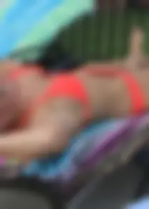 Sexy blonde lady in a bikini with a great body laying by the pool