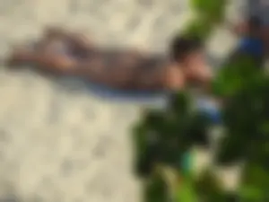Big booty beach babe laying out in thong