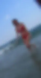 Sexy girl at the beach in a red thong bikini with nice tits and ass