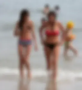 Skinny small boobed girl in a bikini on the beach with her friend