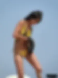 Topless lady on the beach in a gold thong with a nice ass