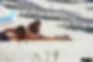 Topless milf and her topless daughter on the beach