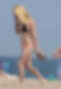 Hot blonde in peach and black bikini on the beach