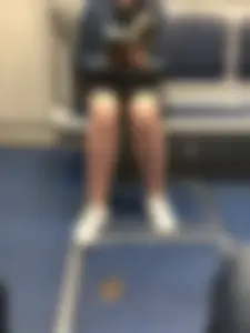 Stocky Girl in a Skirt Reading a Book in Subway Train with Slighty Spread Legs