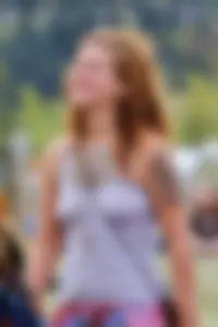 Cute hippie chick in tank top with no bra showing pokies