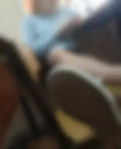 Skinny Girl Sitting With Crossed Legs on Two Chairs at the Desk
