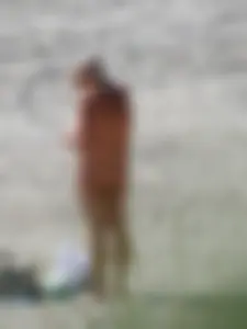 Mature blonde lady on a nude beach with big boobs