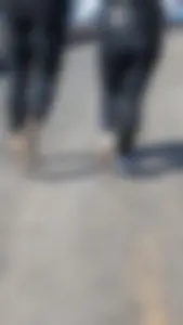 A beautiful little brunette walking in the park. tight black leggings