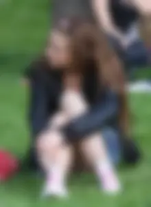 Girl Sitting on a Lawn Flashing Panties Under a Denim Skirt