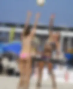 Hot girls playing beach volleyball in bikinis and shorts