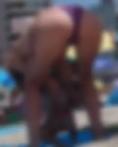 Sexy milf at the beach in a colorful semi thong bikini