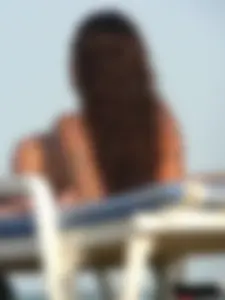 Topless tattooed lady on the beach with fake big tits