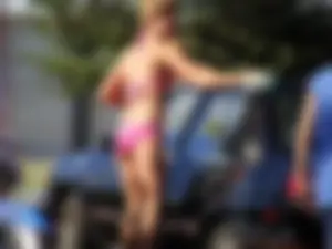 Group of cute girls at a car wash in bikinis and shorts