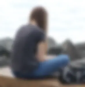 Cute brunette in jeans by the water