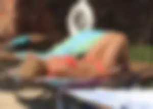 Sexy blonde lady in a bikini with a great body laying by the pool