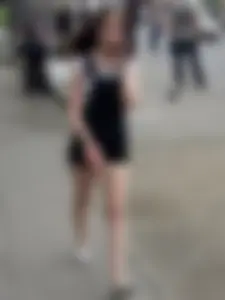 Cute teen candid girl wearing shorts and flats walking down the street, busting the photographer