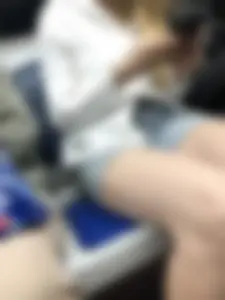 Candid girl in denim shorts sitting in a subway train, hot legs with pale skin