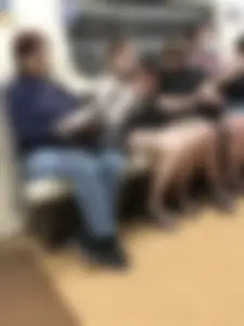 Cute pale teen in shorts in subway train, closeup of her legs