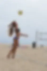 Sexy beach volleyball girl in sport bra top with pokies and blue bikini bottom