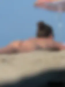 Sexy babe with a nice body topless and in a thong on the beach