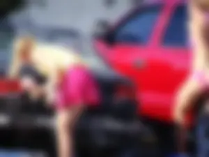 Group of cute girls at a car wash in bikinis and shorts