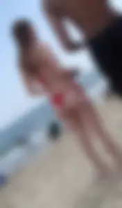 Sexy girl at the beach in a red thong bikini with nice tits and ass
