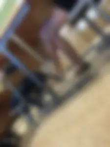 Crossed Slim Legs of a Candid Teen Sitting in Class Dangling Her Flats