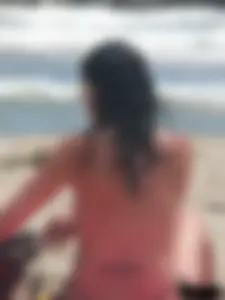Brunette lady topless and in a black thong on the beach