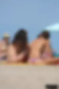 2 topless girls at the beach in thongs