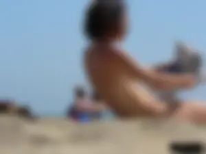 Topless beach milf looking sexy in a tiny g-string bikini