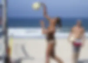 Hot girls playing beach volleyball in bikinis and shorts