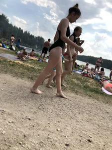 Cute Barefoot Girl in a Black Body Swimsuit Walking on a Road
