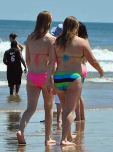 Two beach friends in bikinis one with back dimples and the other thick
