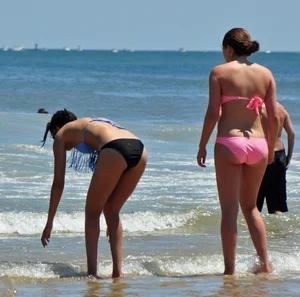 Two teen friends in bikinis at the beach