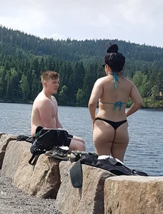 Thick brunette at the lake in a black thong bikini