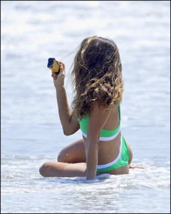 Super hot beach babe with a perfect body in a green thong bikini