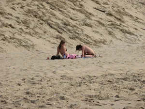Topless beach girl with nice titties with her friend in a bikini