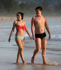 Cute Asian in bikini on the beach with her boyfriend
