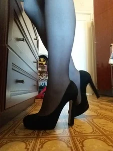 Thin Legs in Black Pantyhose and Black High-Heeled Shoes Closeup Candid Photos