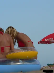 Sexy mom and daughter in red thongs at the beach