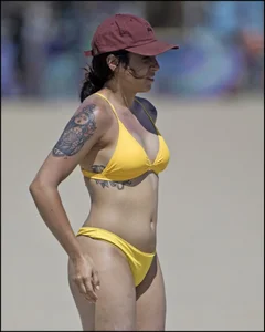 Sexy tattooed beach brunette with a great ass in yellow thong bikini