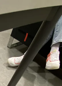 Feet of a Masked Girl in Sneakers Sitting With Crossed Legs