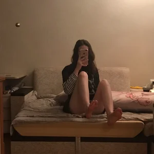 A Skinny Barefoot Girl Taking a Mirror Selfie in Bed