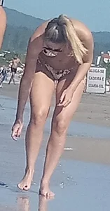 Smooth bodied and sexy blonde at the beach in a thong bikini
