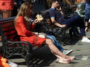 Girl Sitting on Street Bench with Bare Feet Candid