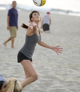 Hot girls playing beach volleyball in bikinis and shorts