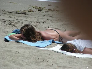 Topless girl with tan lined tits and in a black thong bikini