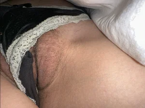 Under blanket closeups of a girl's crotch, panties slip and reveal her hairy pussy